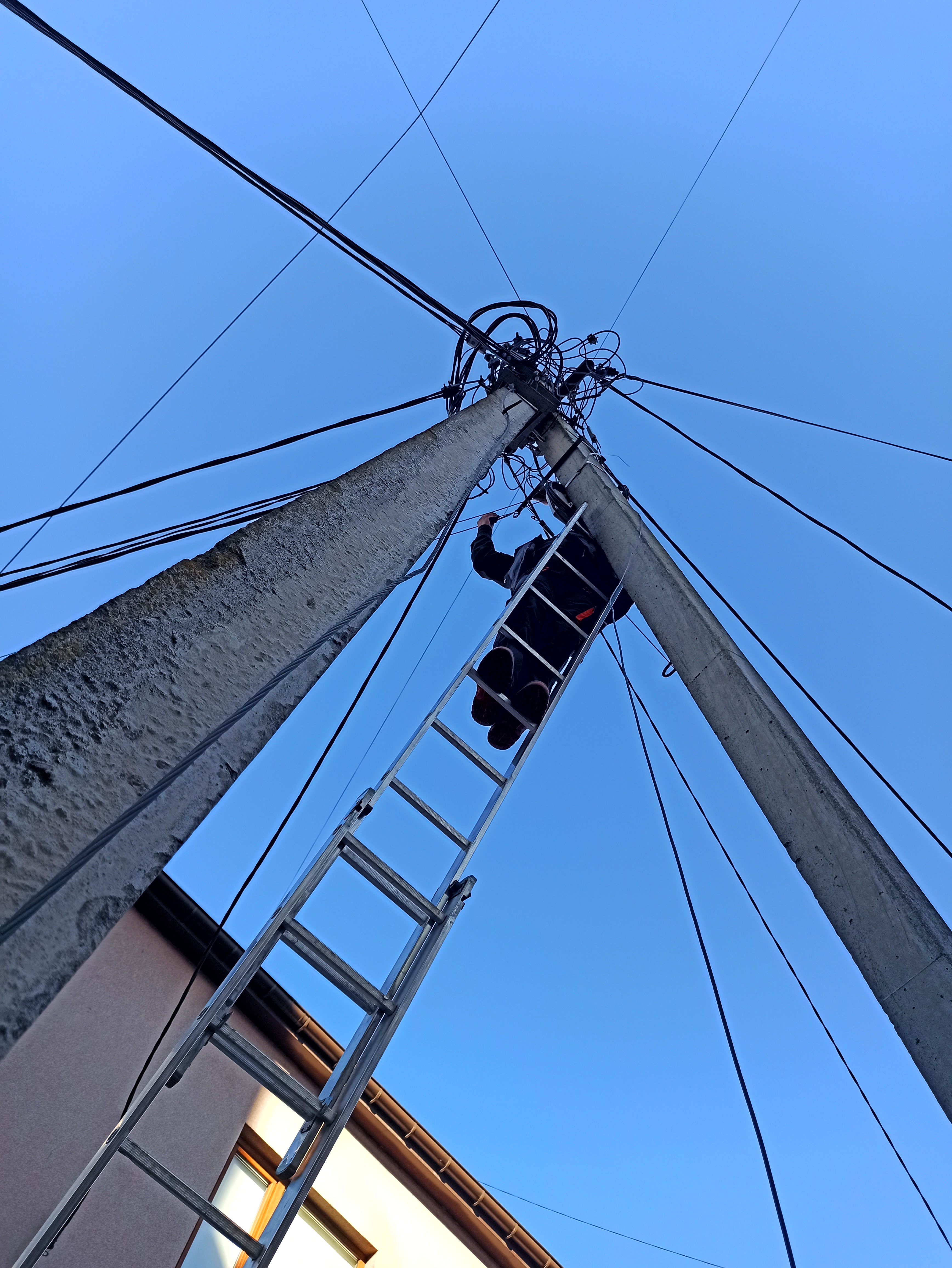 Telecommunications technician installing fibre optic network equipment